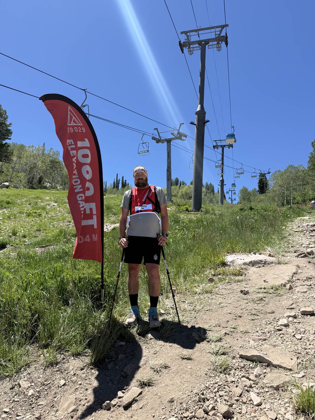 Bruce mid-lap with trekking poles at the 1,000 ft elevation gain banner on the Snowbasin course
